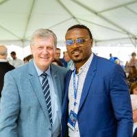 President Tom Haas posing with a guest at the Jamie Hosford Football Center dedication.